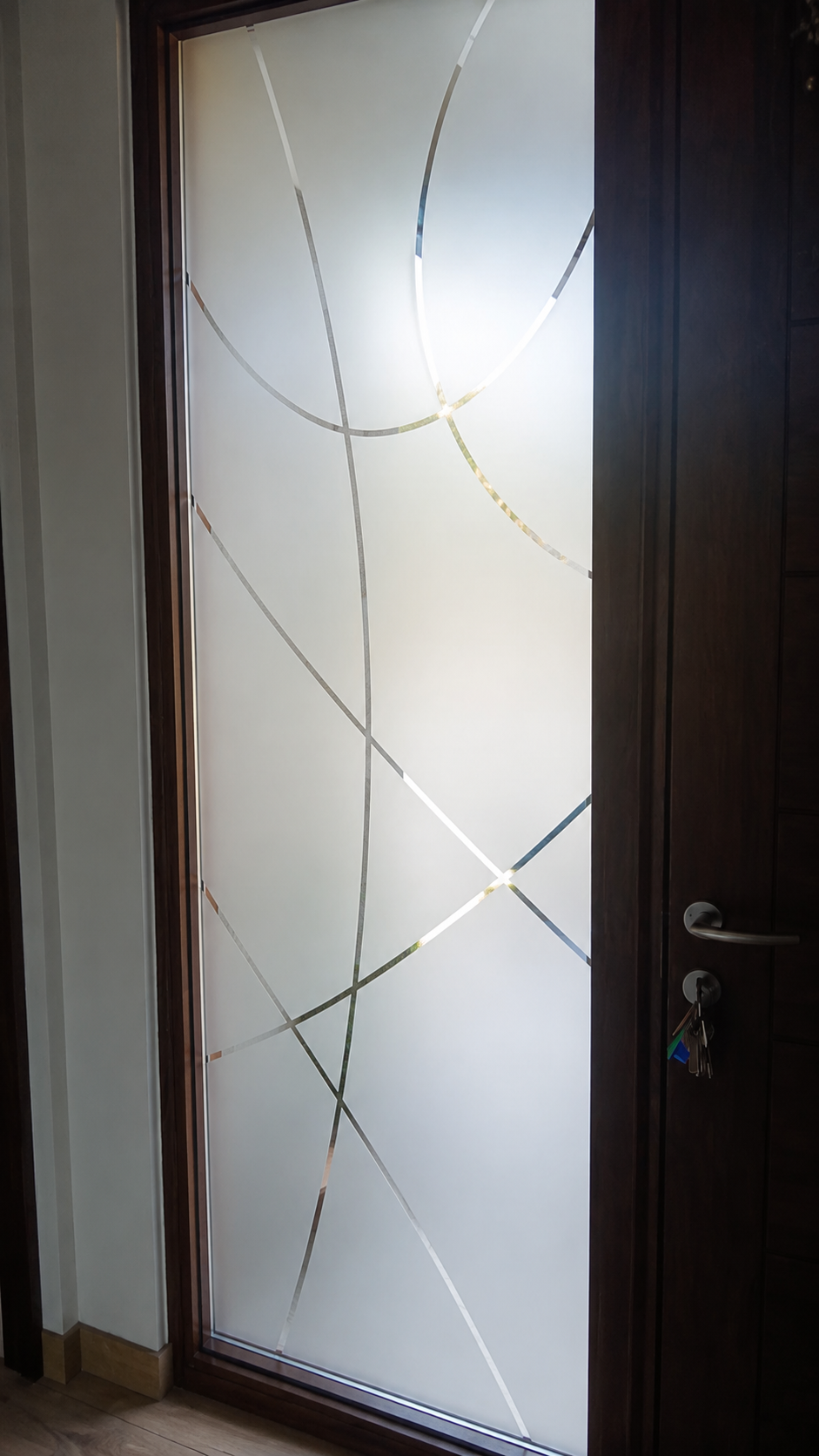 Puerta de vidrio con empavonado decorativo de curvas
